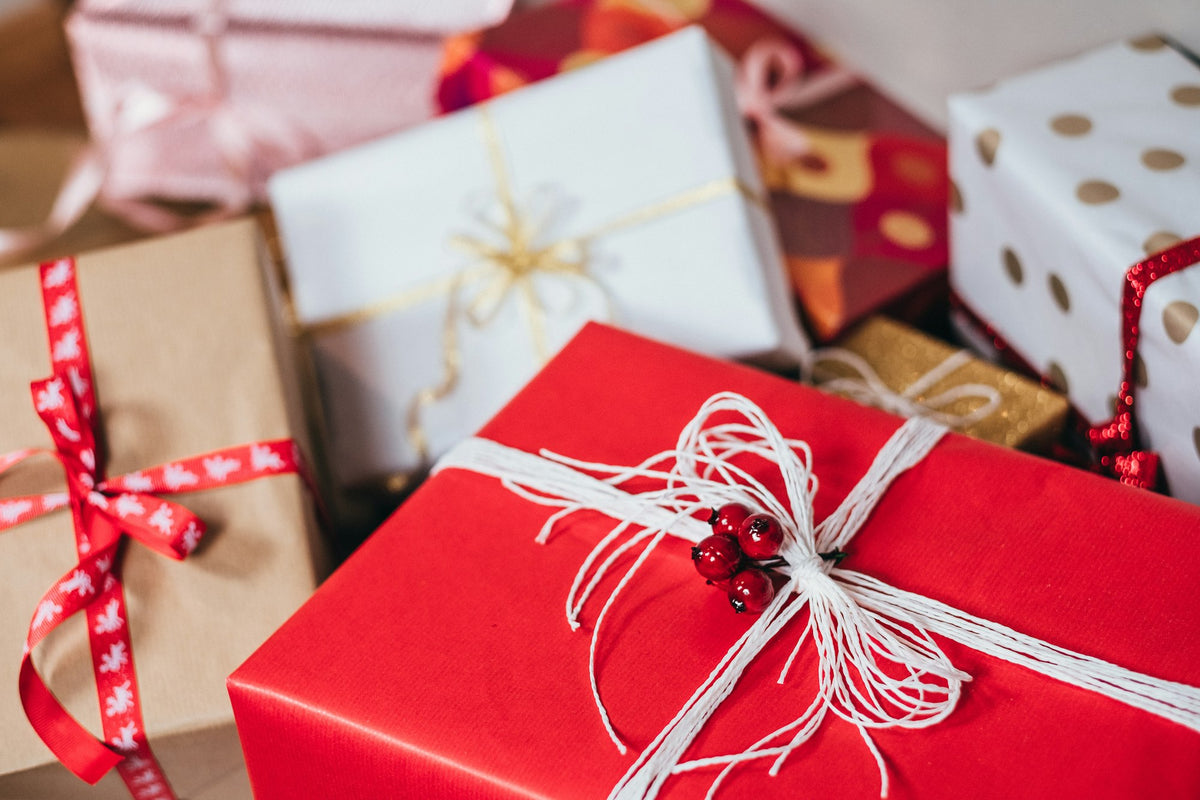 Stack of wrapped gift boxes with ribbons, gifts under $50
