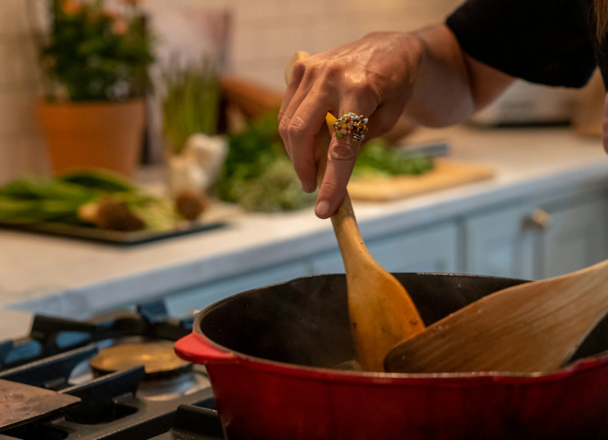 Home cook stirring a pot with a wooden spoon, gifts for home cooks